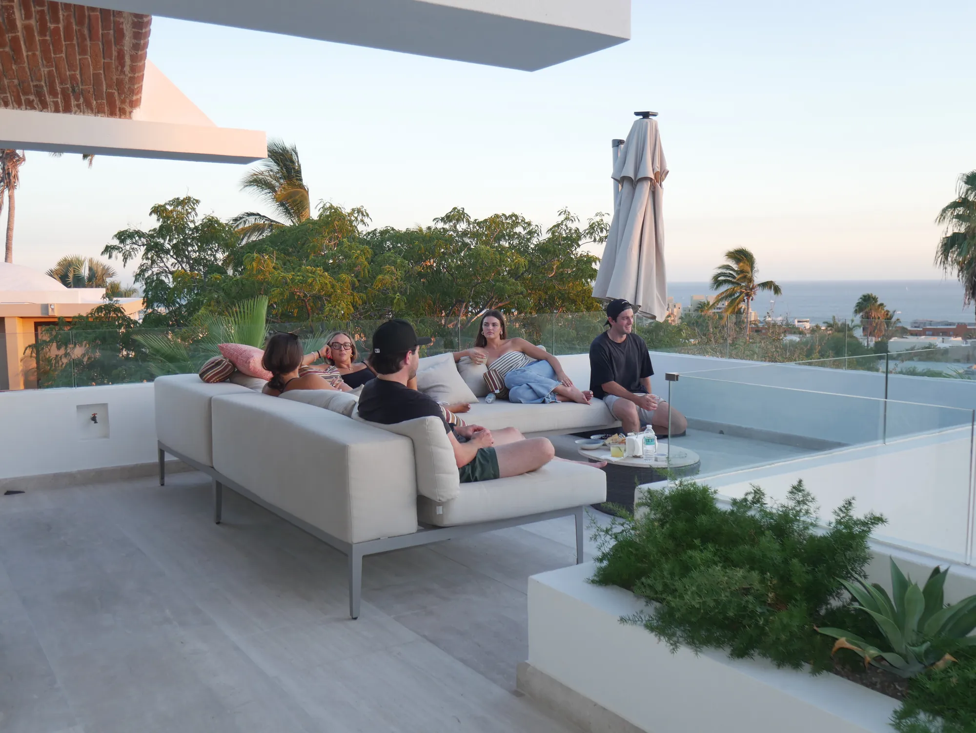 Guests relaxing at the rooftop lounge with an ocean view